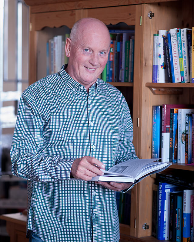 Business coach with book in library